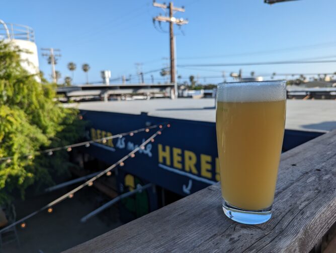 A glass of a hazy beer on a rooftop deck