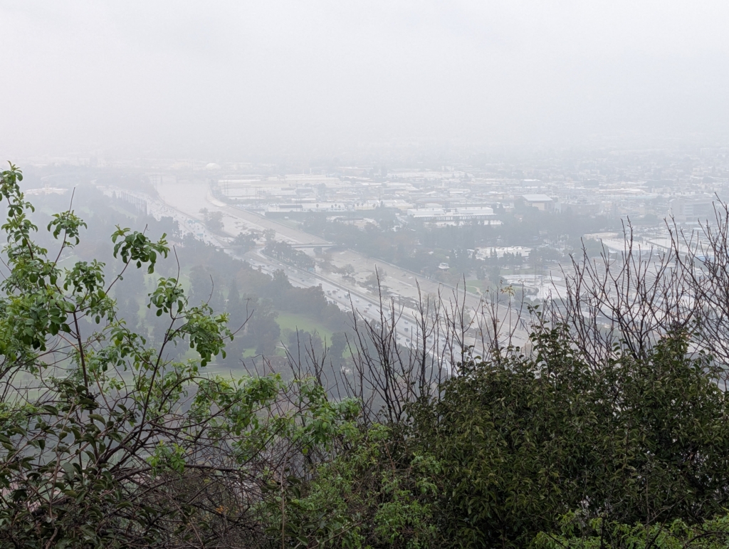 A photo overlooking a rainy 5 freeway and a full LA River from Bunker Hill